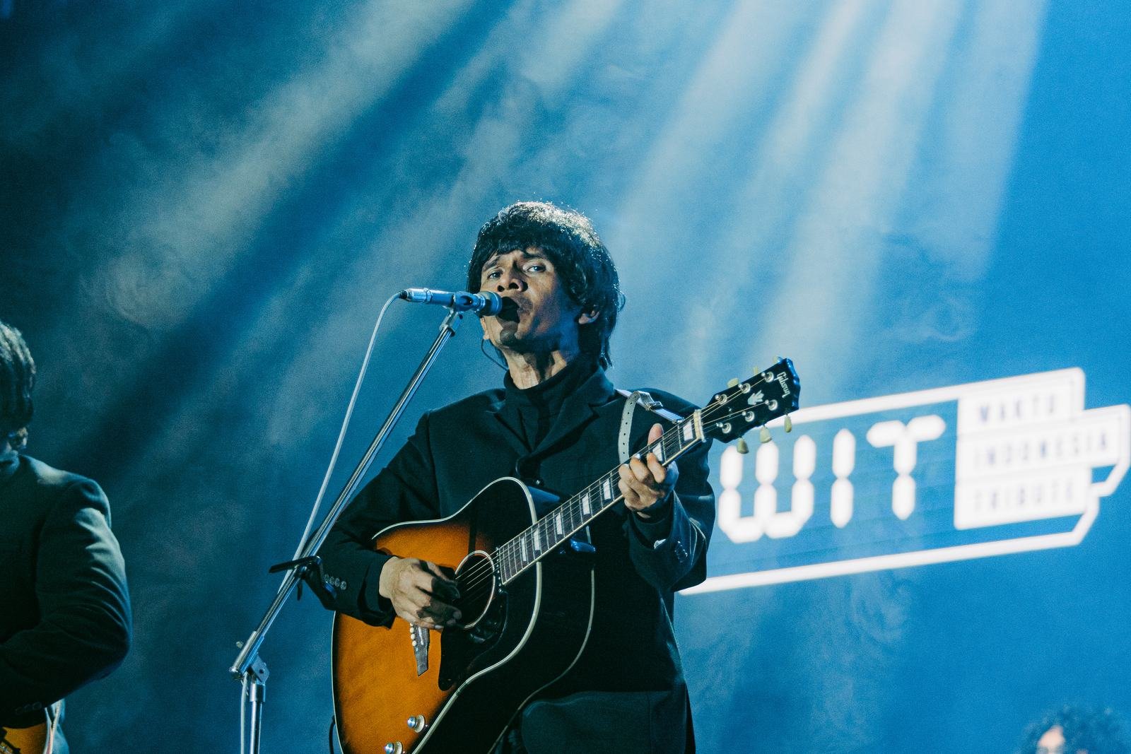 Penyanyi dengan gitar di bawah lampu biru
