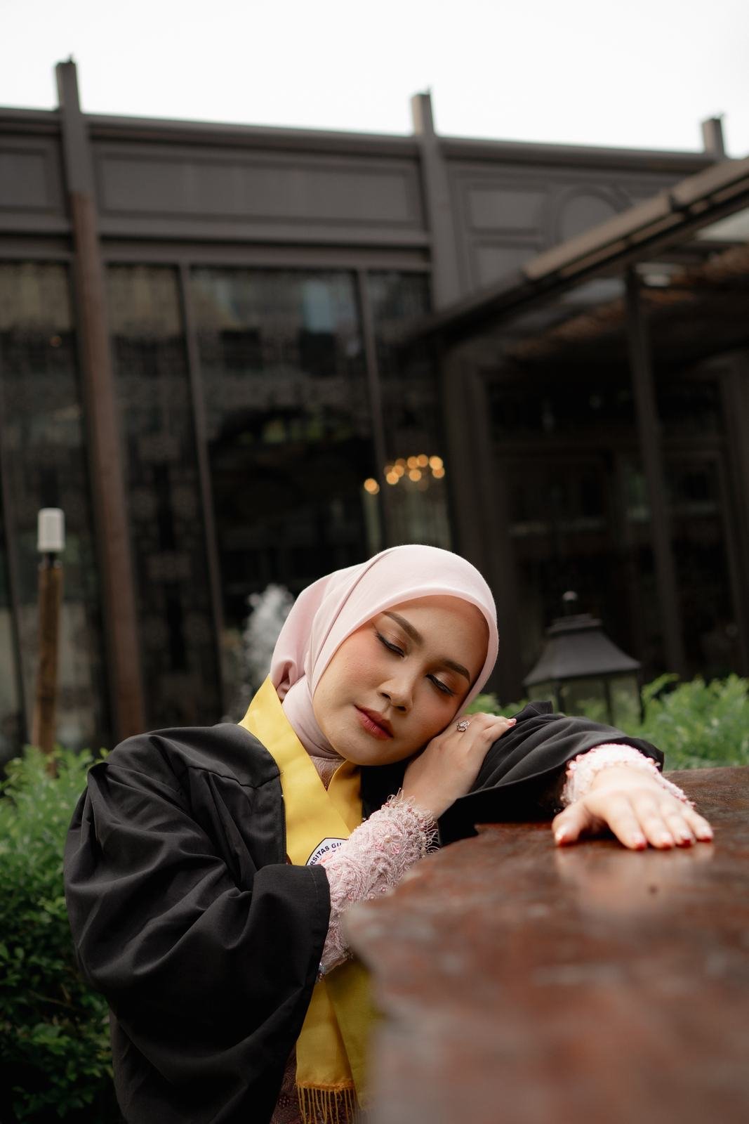 Wisudawati di depan bangunan